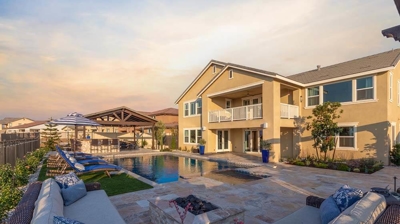 Outdoor retreat featuring pool, spa, lounge chairs, and stunning sunset scenery. Photo