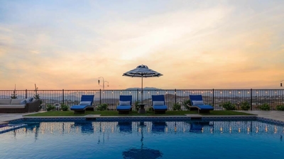 Sunset-facing backyard retreat with pool, spa, lounge chairs, and relaxation. Photo