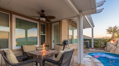 Seating area with a fire pit next to a backyard pool. Photo