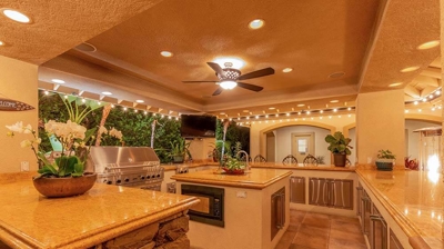 A luxurious outdoor living space complete with a full sized kitchen and grill. Photo