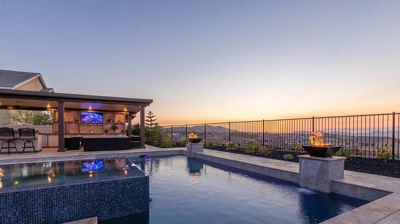 Gorgeous sunset with a backyard pool and patio. Photo
