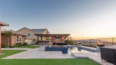 An outdoor pool in a backyard with a sunset provides a picturesque setting for relaxation and enjoyment. Photo