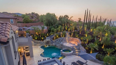 Aerial shot of pool in backyard with overhead lights. Photo