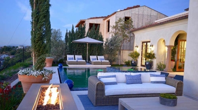 Lounge area of backyard with fireplace and furniture. Photo