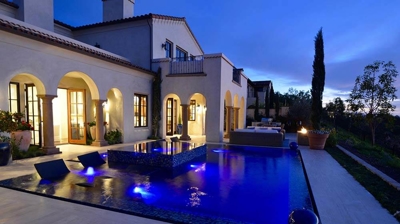 Lit up pool in backyard. Photo