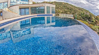Crystal clear pool with beautiful home. Photo