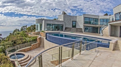 Backyard view of pool and jacuzzi within gorgeous home. Photo