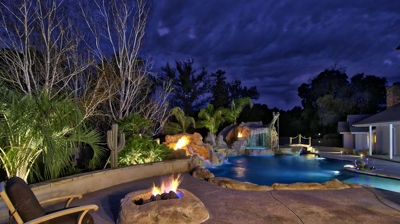 Custom patio with fire feature illuminated at night Photo