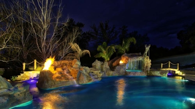 Custom pool with fire features at night Photo