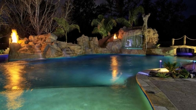 Custom pool with fire and water features at night Photo