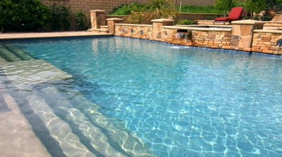 Pool stairs and view of custom water features Photo