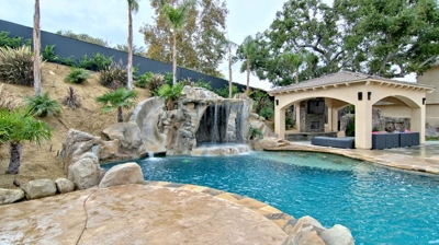 Backyard freeform pool with slide and jacuzzi Photo