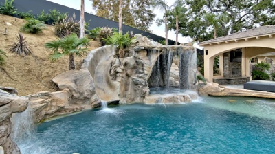 Pool slide with waterfall feature over jacuzzi Photo