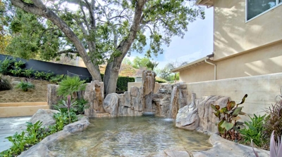 Backyard pool landscaping with water feature Photo