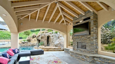 Lounge area with TV and fireplace under gazebo Photo