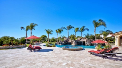 Pool with jacuzzi with lounge chairs and palm trees Photo