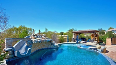 Beautiful backyard swimming pool with slide and jacuzzi Photo