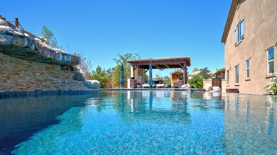 Backyard pool with covered patio Photo
