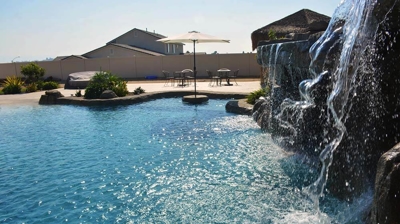 Water trickling down into the pool area from a waterfall Photo