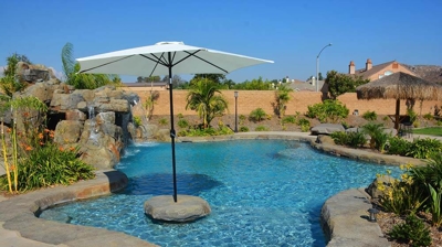 A white umbrella nested within the large pool on a hot summer day Photo