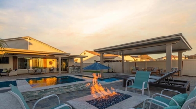 A lit fire within the fireplace in the lounging section of backyard Photo