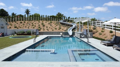 Square design of pool with a waterslide built in Photo