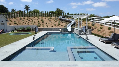 Square design of pool with a waterslide built in Photo