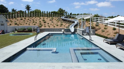 Square design of pool with a waterslide built in Photo
