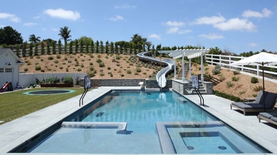 Square design of pool with a waterslide built in Photo