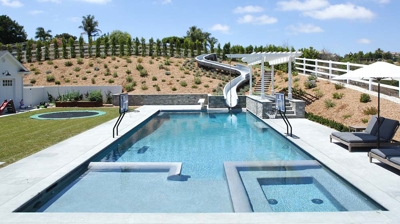 Square design of pool with a waterslide built in Photo