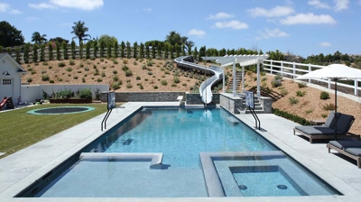 Square design of pool with a waterslide built in Photo