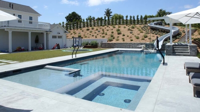 Side angle view of pool with a waterslide built in Photo
