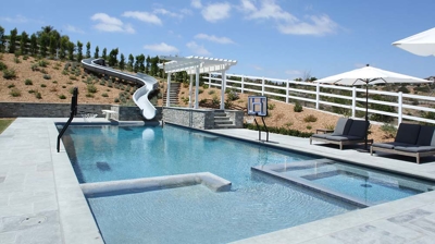 Side angle view of pool with a waterslide built in Photo