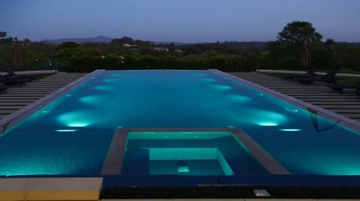 Contemporary outdoor pool illuminated with captivating lights. Photo