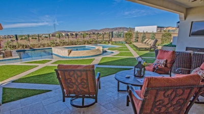 Pool chairs within lounging area alongside a gorgeous pool Photo