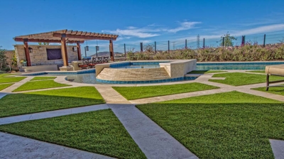 Green grass landscaping design with patio and pool in view Photo