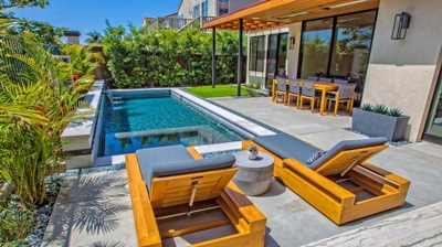 Lounging pool chairs within modern backyard and pool Photo