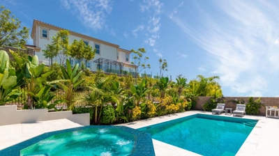 Rectangular pool and oval jacuzzi with lounging chairs on a sunny day Photo