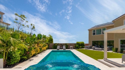 Rectangular pool and oval jacuzzi with lounging chairs on a sunny day Photo
