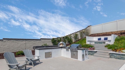 Patio section of backyard with lounge chair and outdoor grill station Photo
