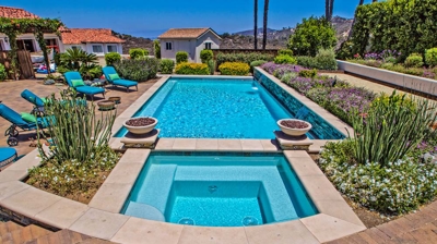 Overhead view of large pool and jacuzzi with lounging chairs on a sunny day Photo