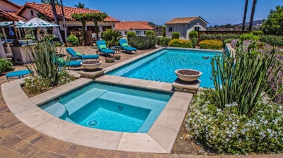 Overhead view of large pool and jacuzzi with lounging chairs on a sunny day Photo