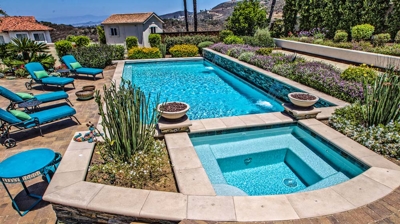 Overhead view of large pool and jacuzzi with lounging chairs on a sunny day Photo