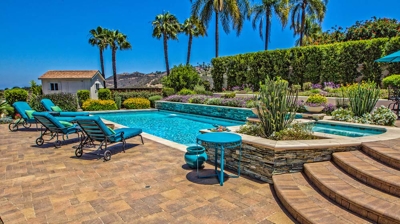 Overhead view of large pool and jacuzzi with lounging chairs on a sunny day Photo