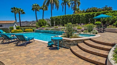 Overhead view of large pool and jacuzzi with lounging chairs on a sunny day Photo