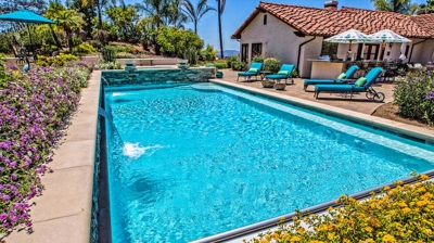Large pool surrounded by bright yellow flowers on a summer day Photo