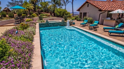 Large pool surrounded by purple flowers on a summer day Photo