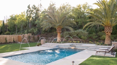 Modern backyard pool with water features and attached spa Photo