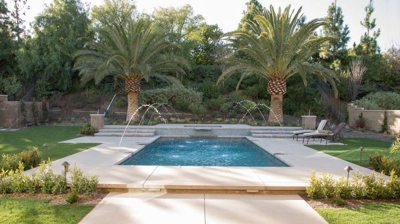 Outdoor pool with deck jet fountains and an attached spa Photo