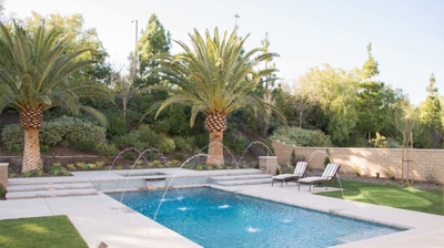 Backyard pool with water features and attached spa Photo